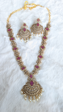 Gold necklace with white and pink stones and matching earrings.