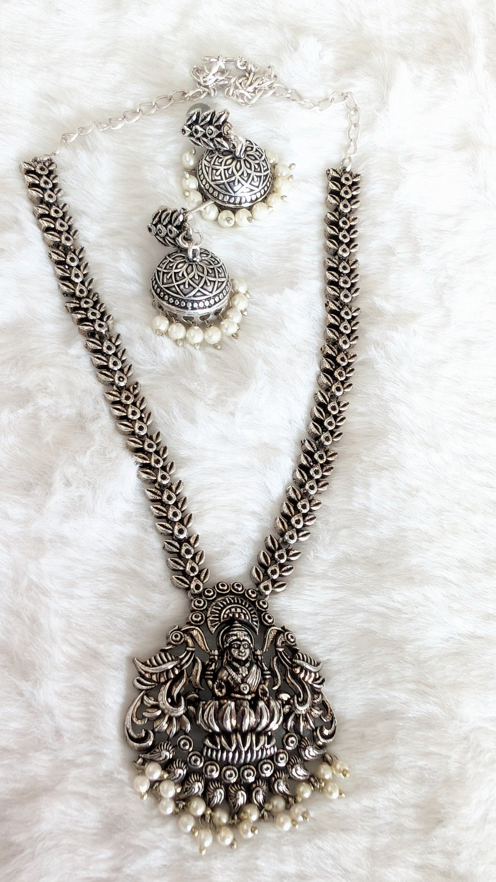 Silver necklace with pendant and matching earrings.