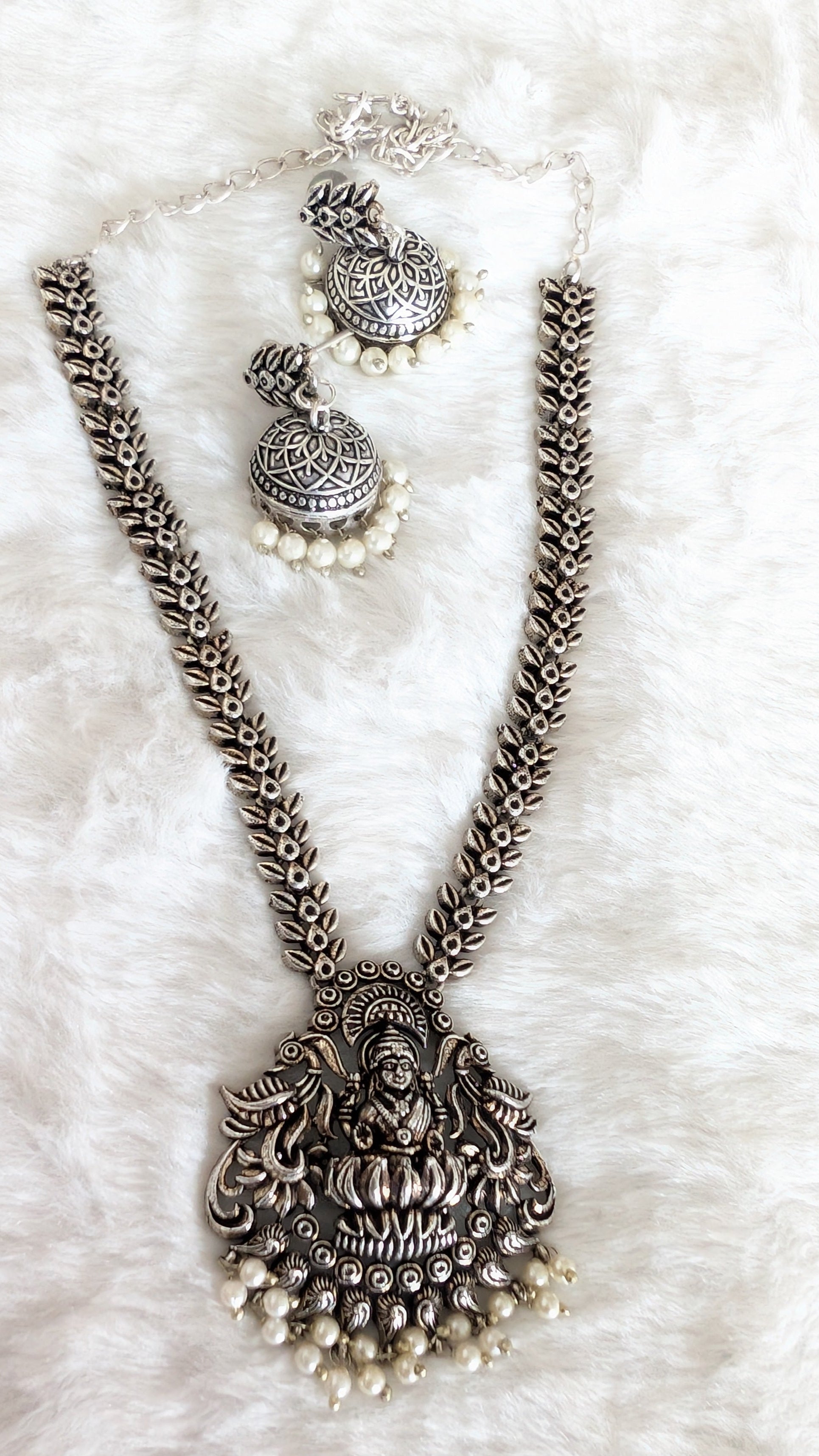 Silver necklace with pendant and matching earrings.