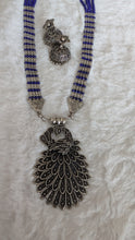 Necklace with intricate silver pendant and blue beads.