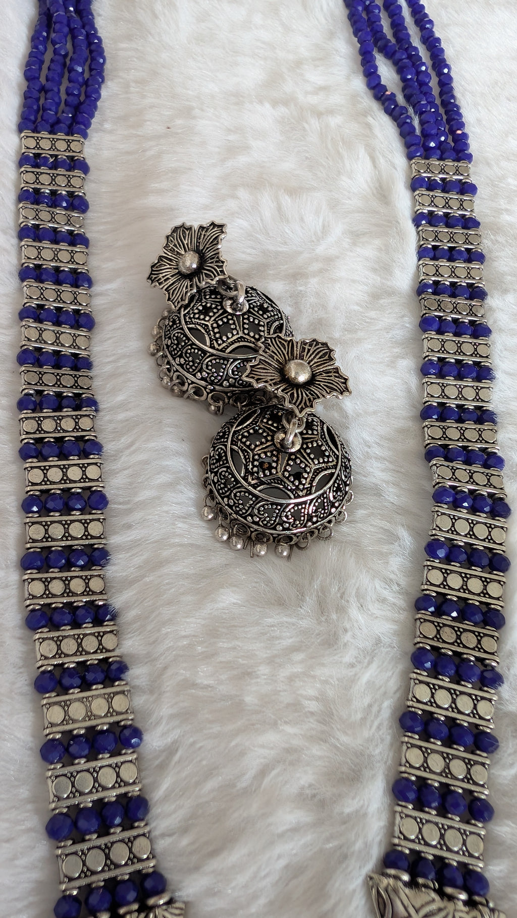 Necklace with intricate silver pendant and blue beads.