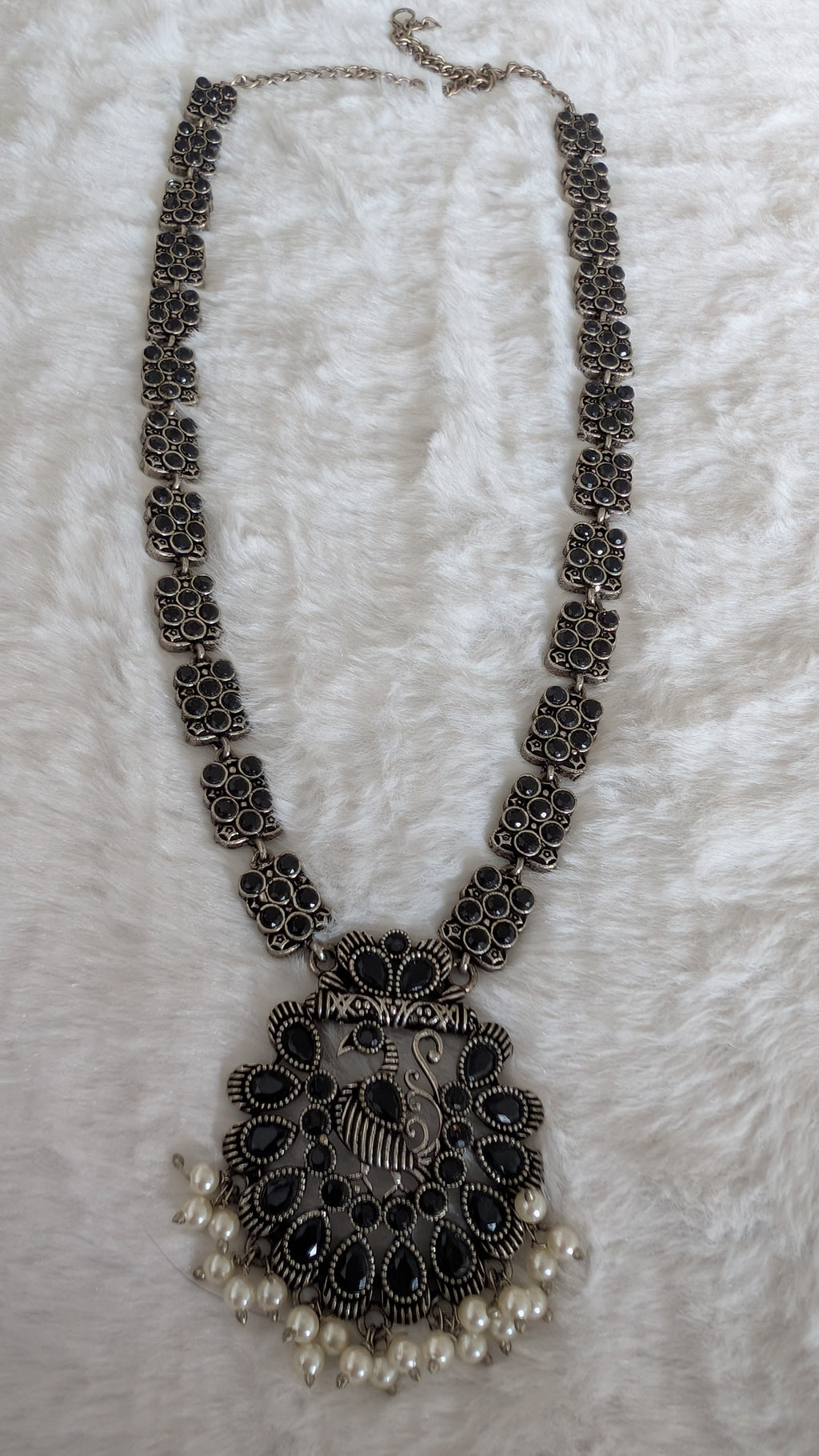 Decorative necklace with intricate design and pearl accents.