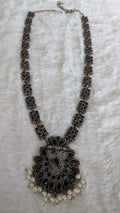Decorative necklace with intricate design and pearl accents.