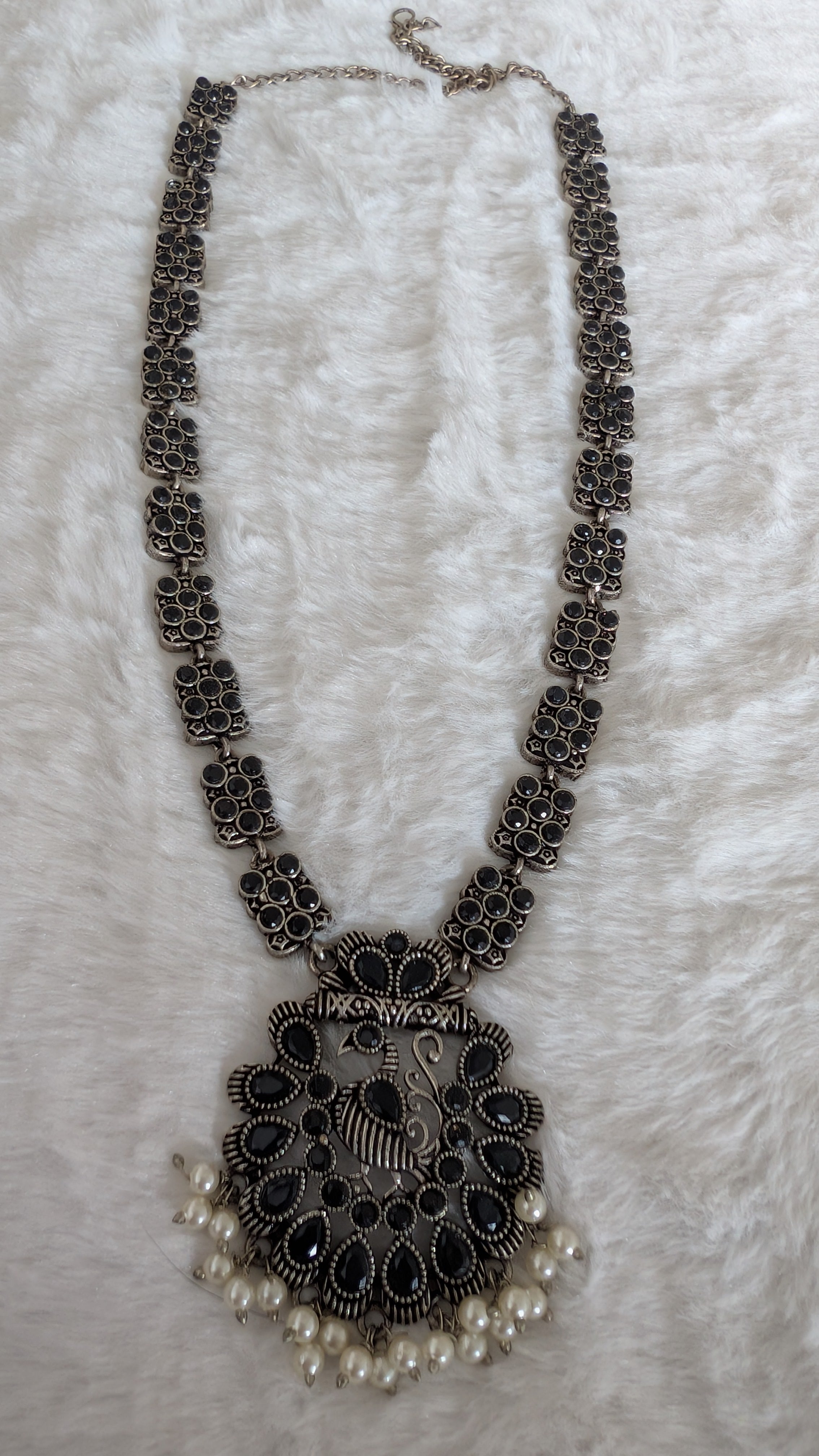 Decorative necklace with intricate design and pearl accents.