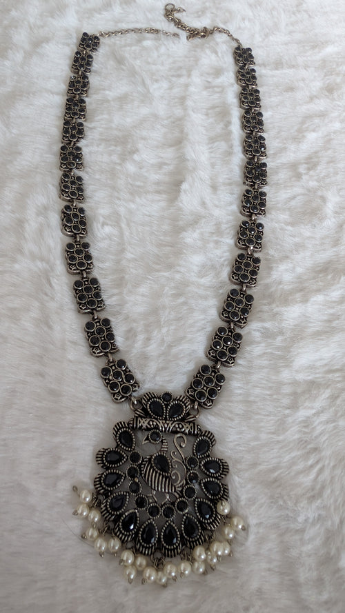 Decorative necklace with intricate design and pearl accents.