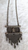 Oxidized silver necklace with intricate design on a white background