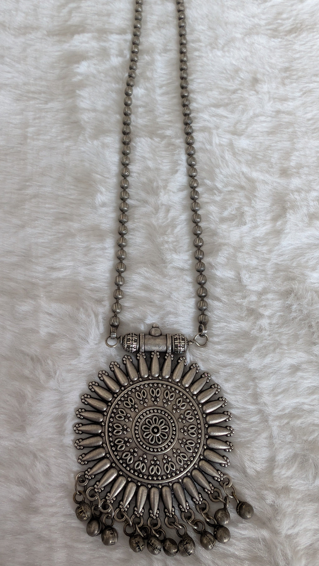 Silver necklace with decorative pendant.