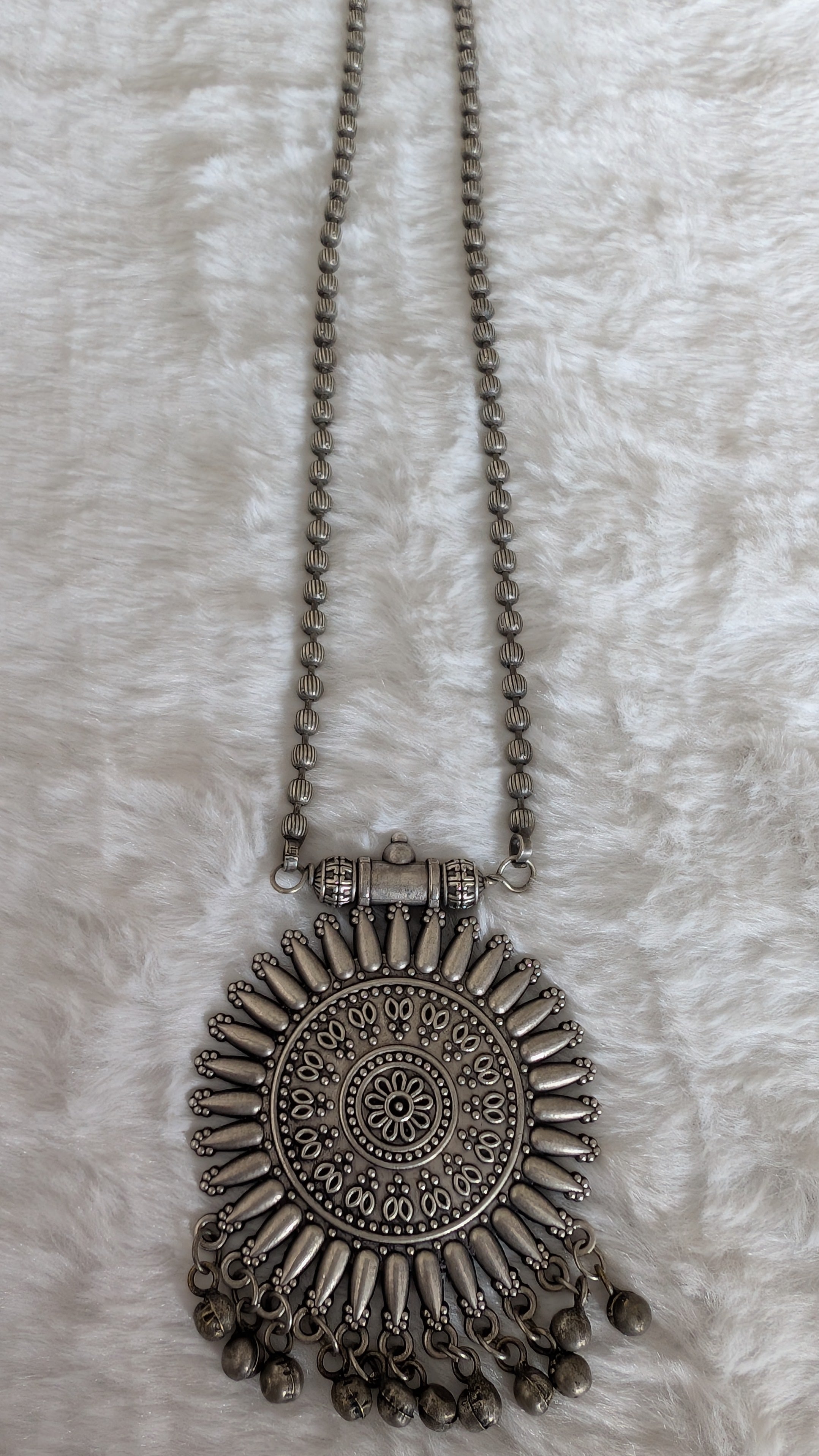 Silver necklace with decorative pendant.