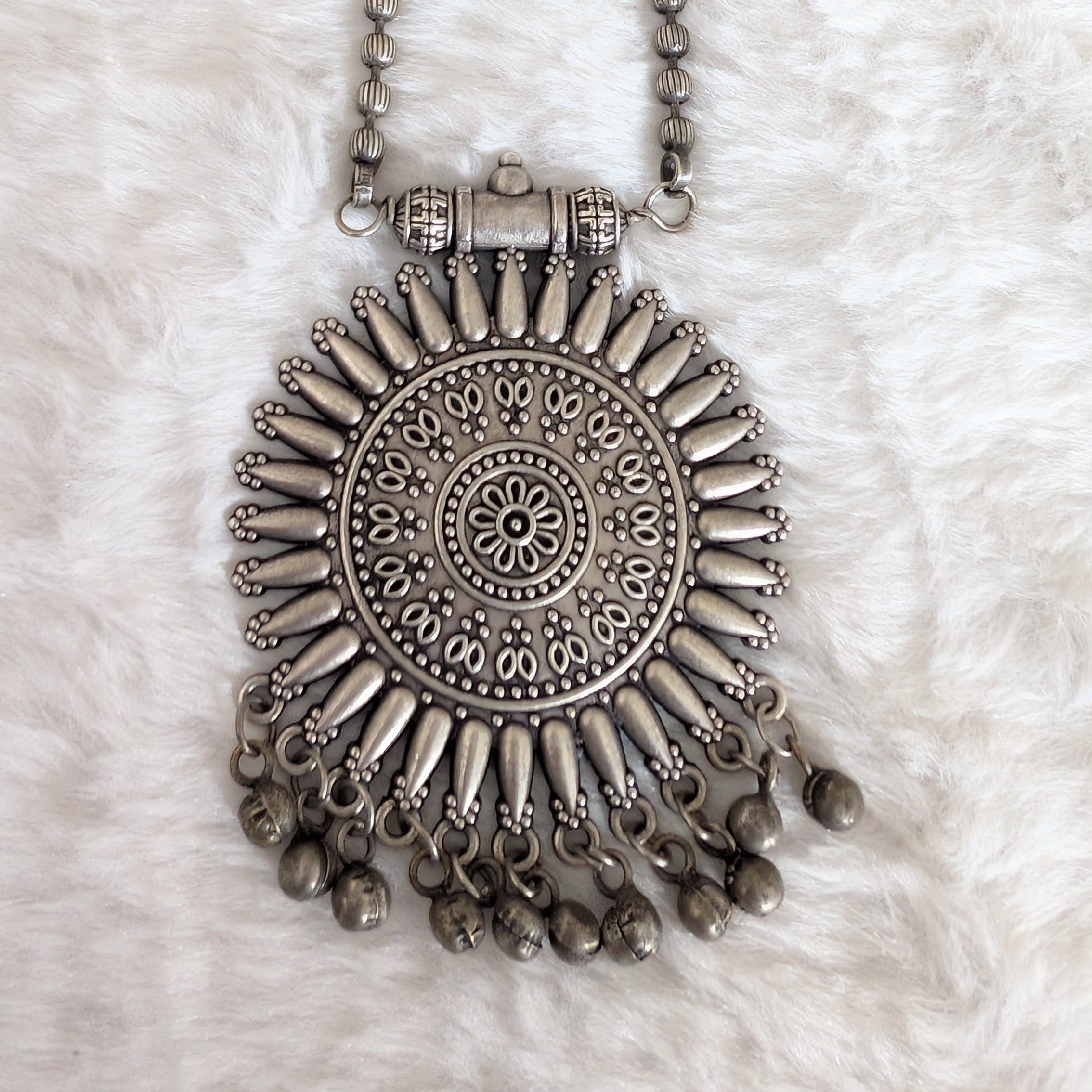 Silver necklace with decorative pendant.